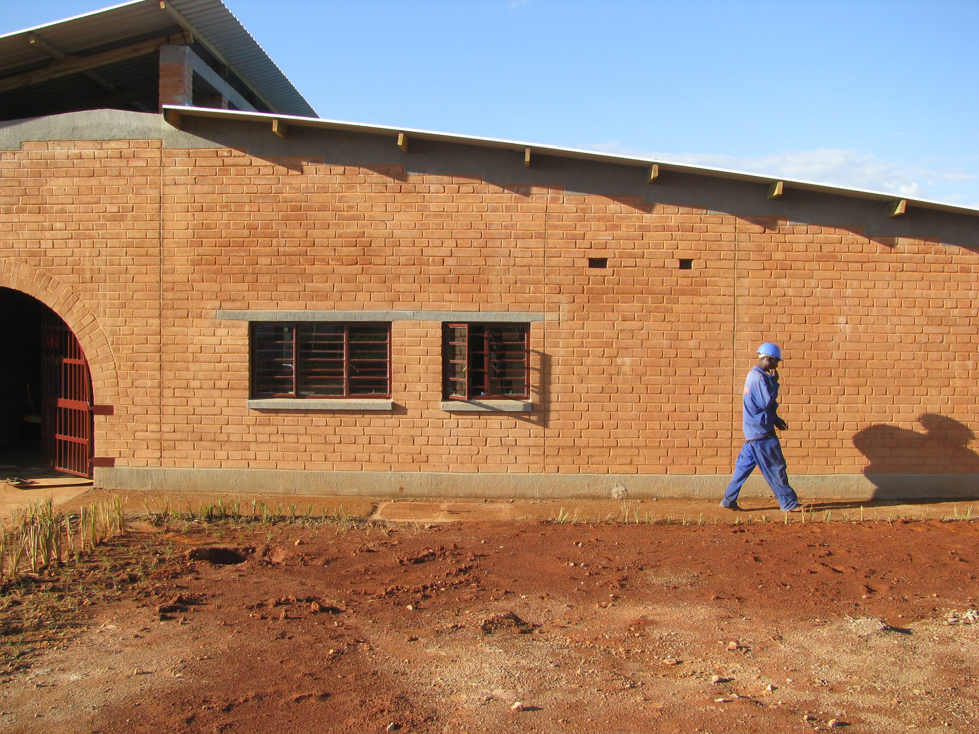 red earthen ceb walls with a worker