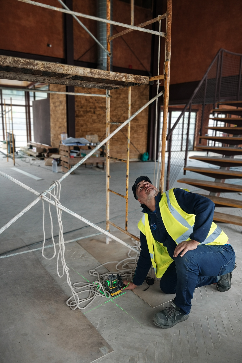 Positioning and alignment of suspended steel fireplace using laser level, Project Outeiro, CAS Studio